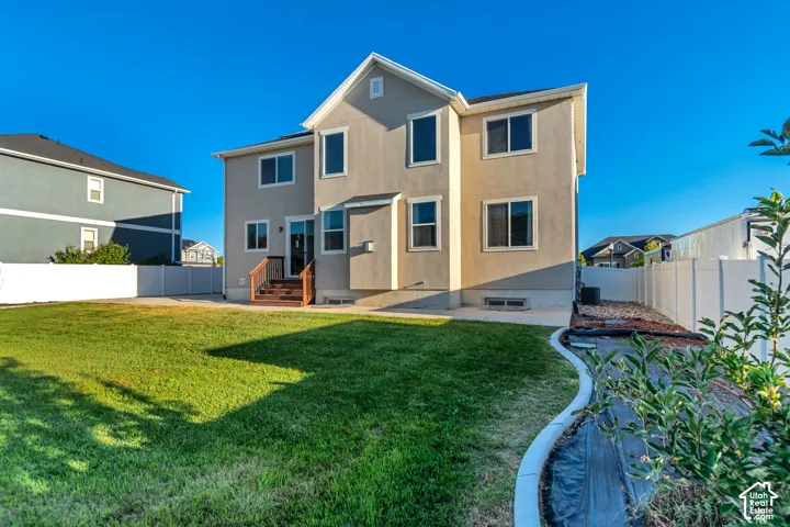 Stucco exterior with multiple windows, leading to a wooden deck