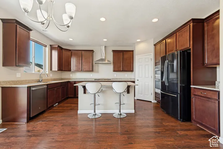 Kitchen featuring wood-finish flooring, dark wood cabinetry, light-toned countertops, and stainless steel appliances