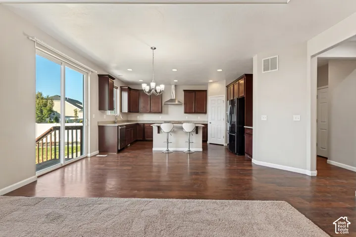 Expansive great room with wood-finish flooring, recessed lighting, and a sliding glass door