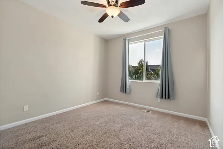 Neutral-toned walls complement the plush carpet flooring