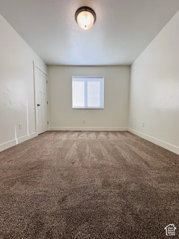 Neutral-toned walls complement the brown carpet flooring