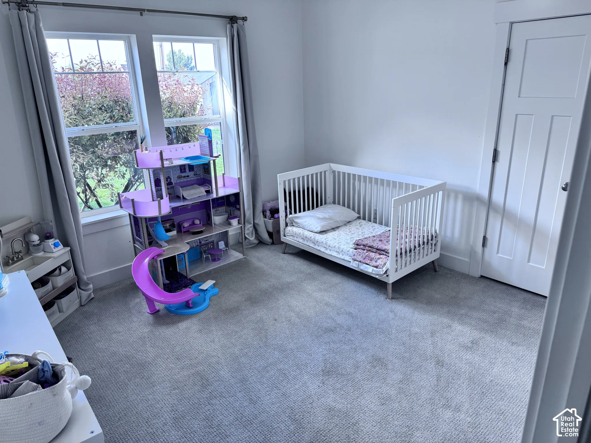Neutral-toned wall-to-wall carpeting, white trim, and a paneled interior door