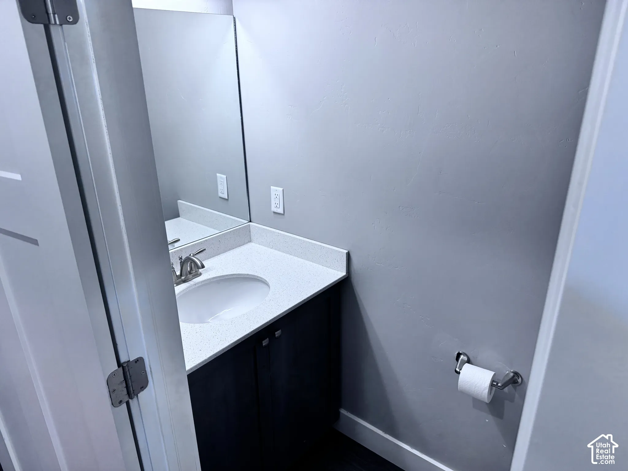 Vanity featuring a white oval sink, brushed nickel faucet, and light-toned countertop