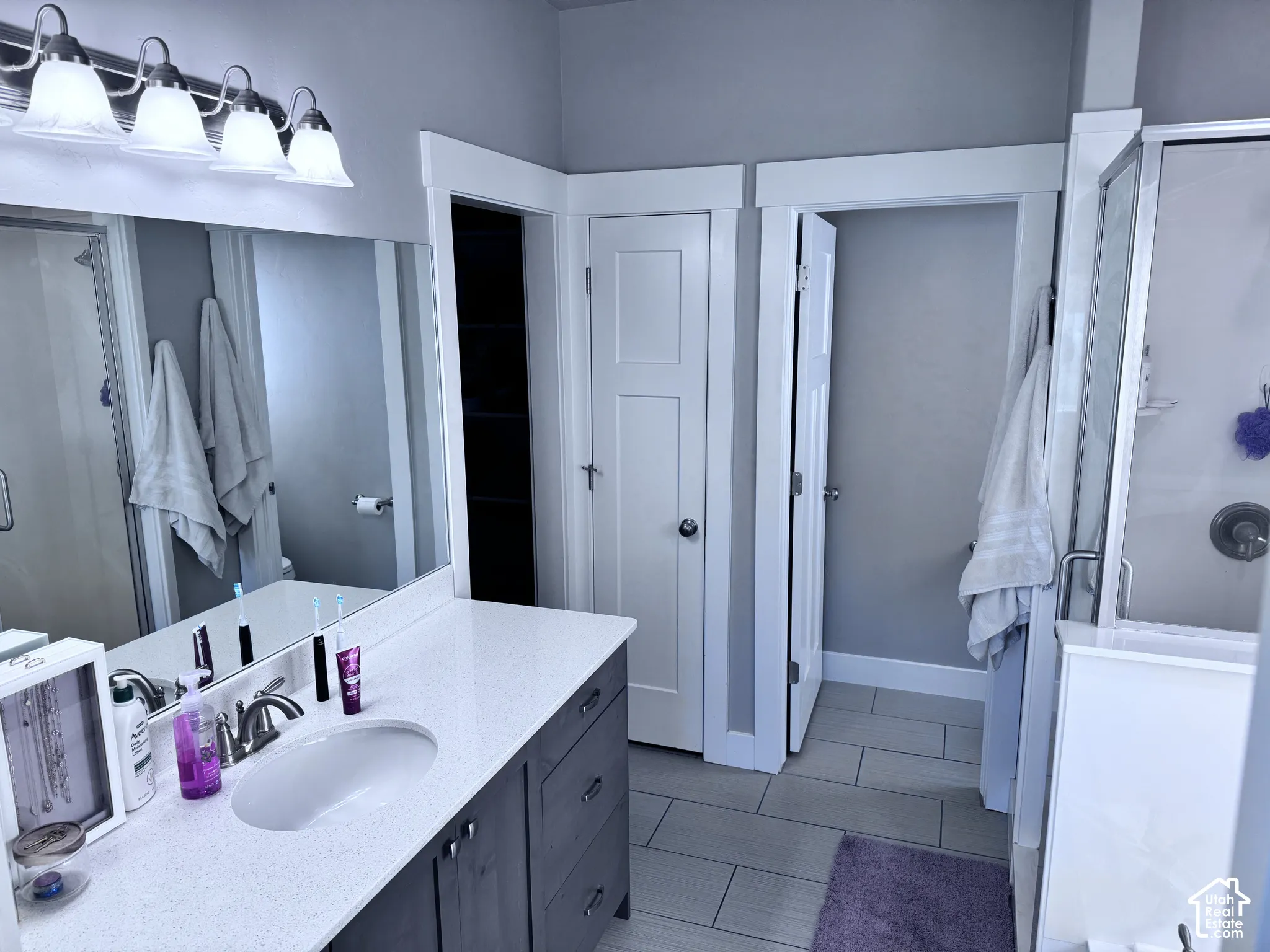 Vanity with a single undermount sink, a quartz countertop, and a brushed nickel faucet