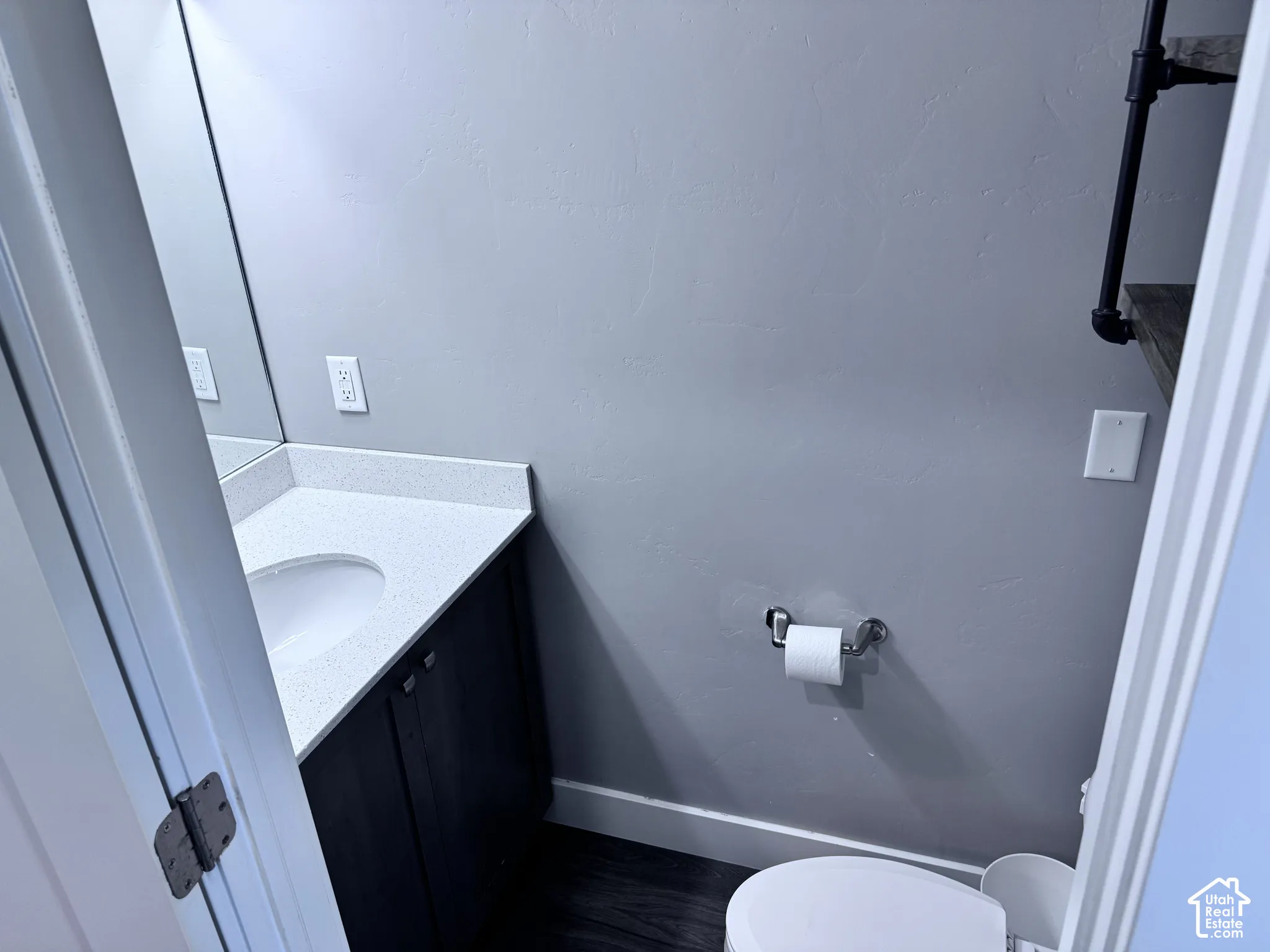 Vanity with a solid surface countertop, built-in sink, and dark wood-finish cabinetry