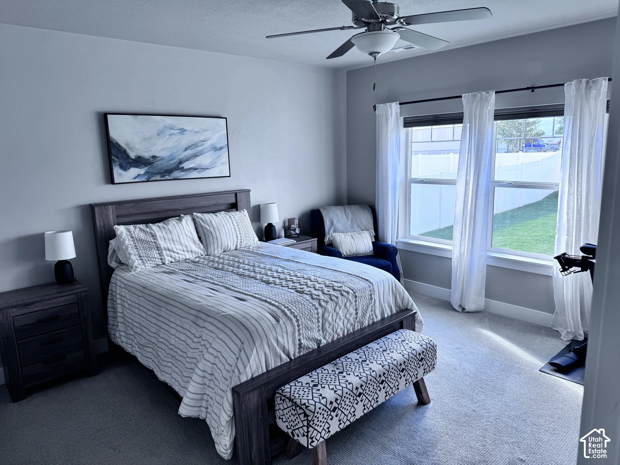 Expansive windows, ceiling fan, and light gray wall finish