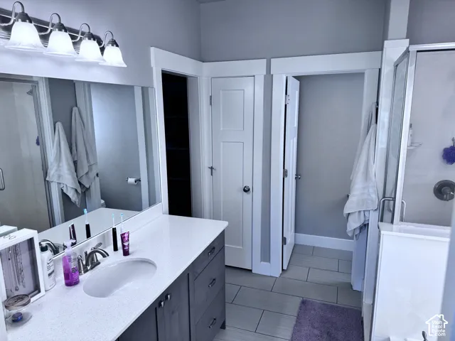 Vanity with a single undermount sink, a quartz countertop, and a brushed nickel faucet
