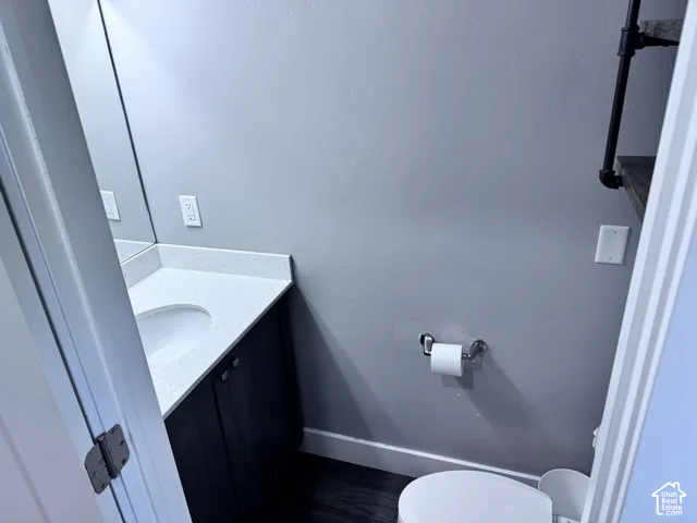 Vanity with a solid surface countertop, built-in sink, and dark wood-finish cabinetry