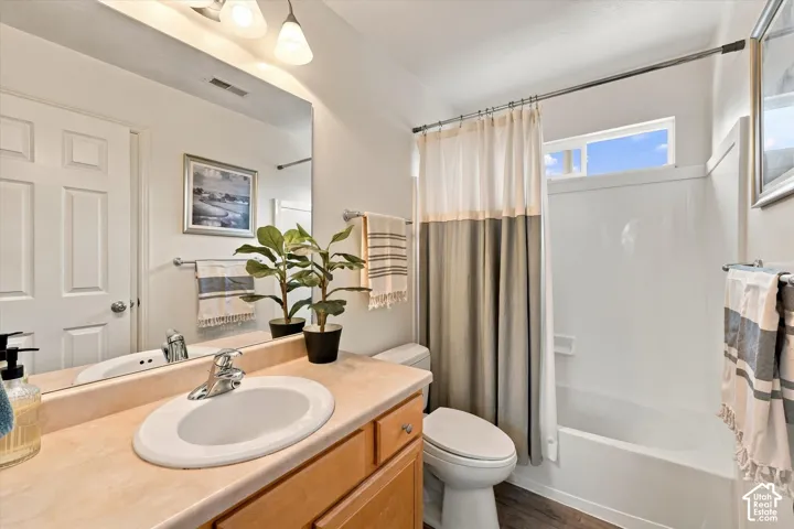 Bright bathroom featuring a wood-finish vanity with an undermount circular sink, wood countertop, and chrome faucet
