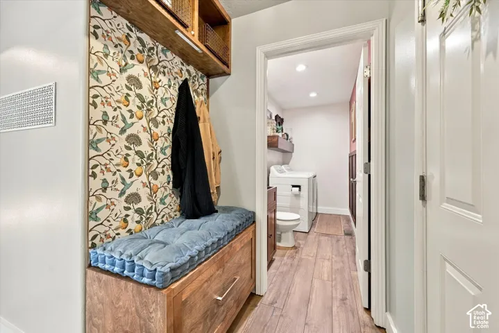 Built-in hall tree with decorative wall paneling and overhead storage
