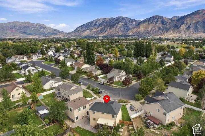 Residential neighborhood with mature trees and mountain backdrop