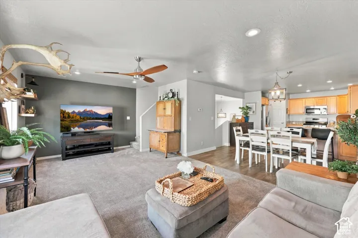 Open-concept living space featuring recessed lighting, a ceiling fan, and carpet flooring