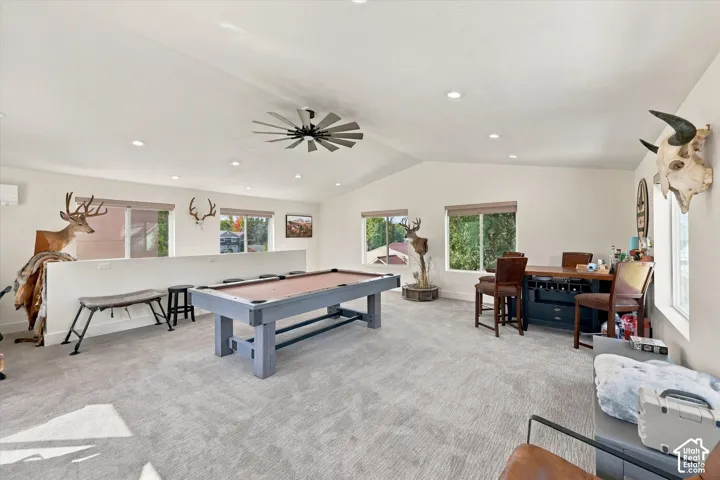 Room above detached garage. Spacious bonus room featuring vaulted ceilings, recessed lighting, a ceiling fan, multiple windows, and light-toned carpet flooring