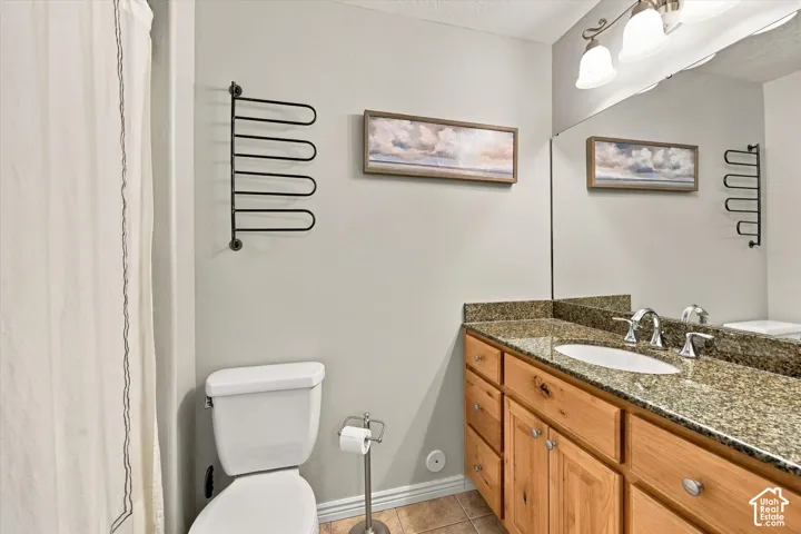 Single vanity with a granite-style countertop, undermount sink, and chrome fixtures