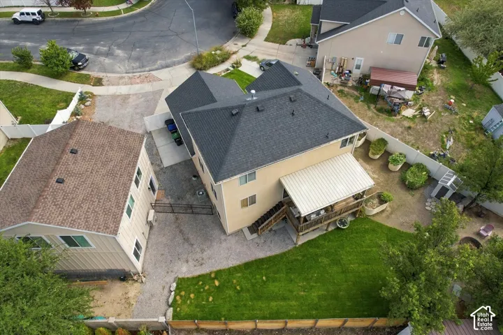 Two-story residence with a covered deck, featuring a manicured lawn area and a gravel driveway