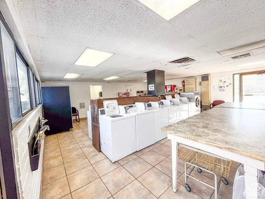 Tiled flooring, multiple windows, fluorescent lighting, and a drop ceiling