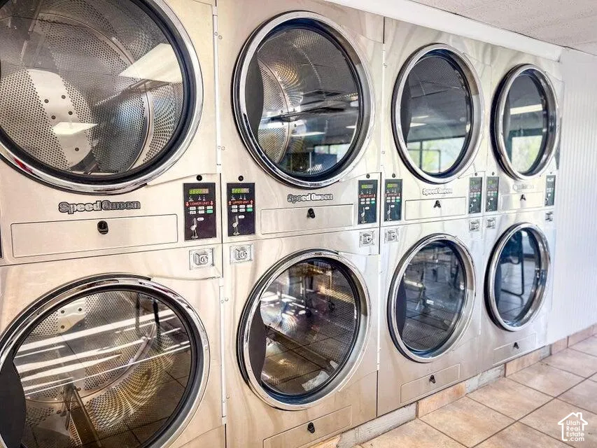 Commercial-grade Speed Queen laundry appliances, multiple washer and dryer units, stainless steel finishes, tile flooring, and integrated control panels