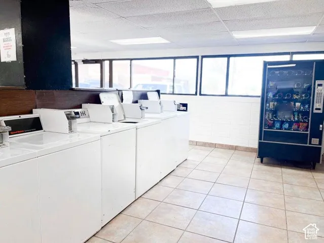Large-format tile flooring, multiple washing machines, recessed lighting, and expansive windows