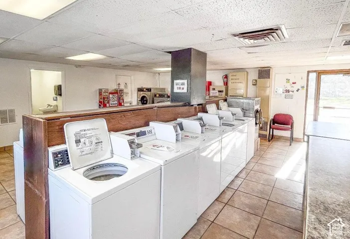 Tile flooring throughout, drop ceiling, and multiple washing machines