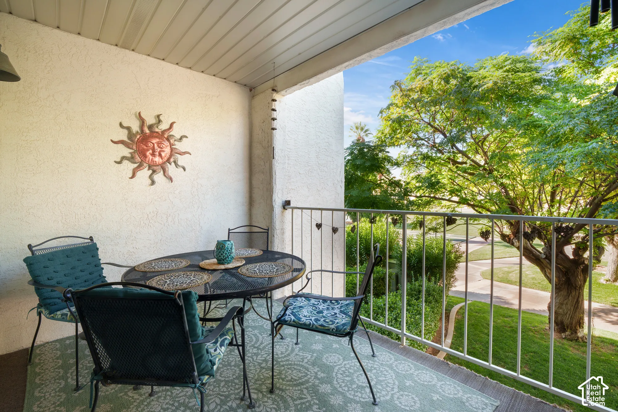 Covered balcony with textured stucco walls and white railing