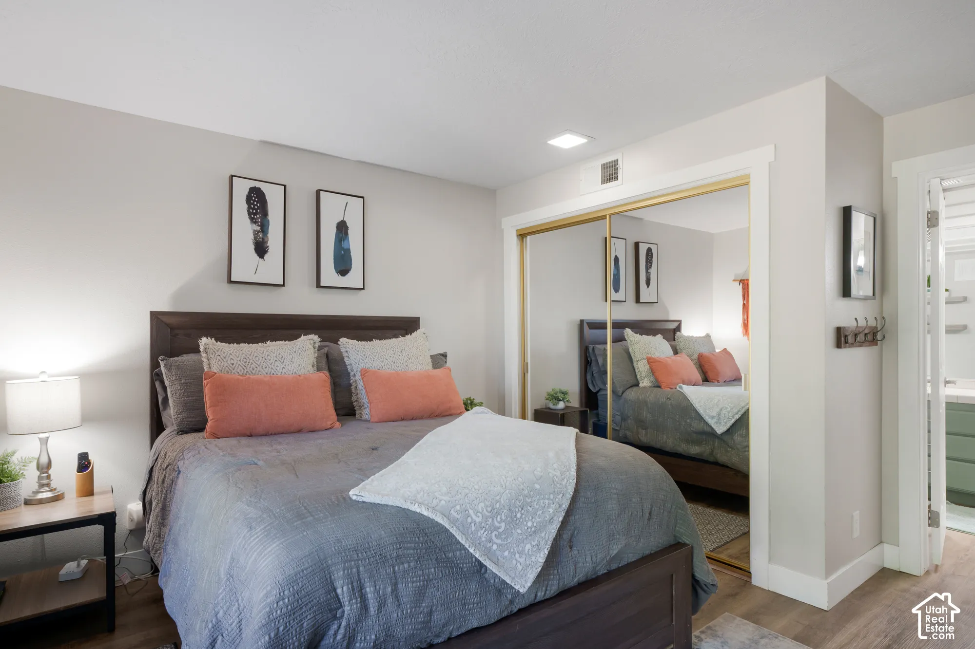 Bedroom featuring wood-finish flooring, mirrored closet doors, and recessed ceiling lighting