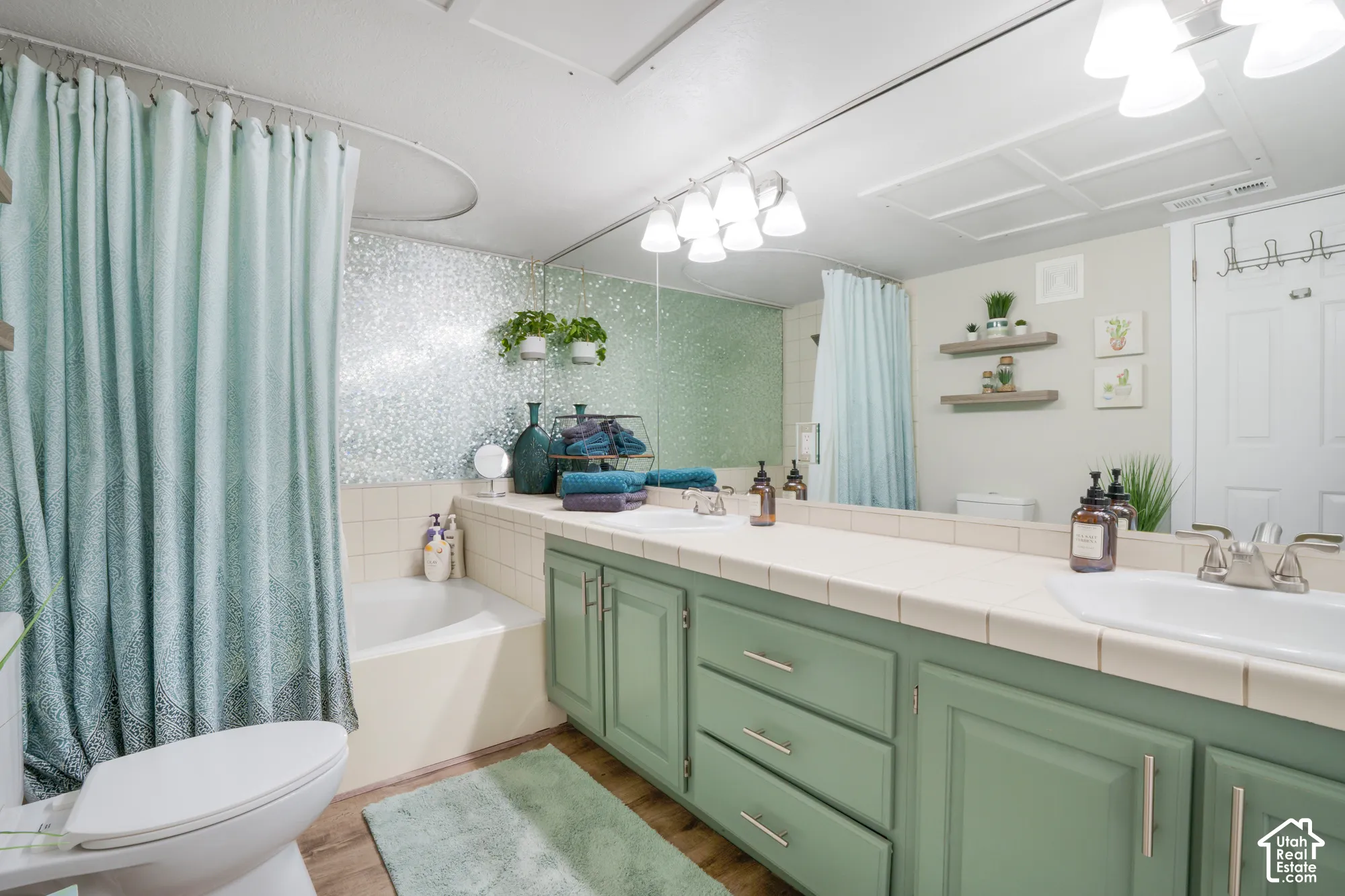 Double vanity with undermount sinks, tile countertop, and green cabinetry