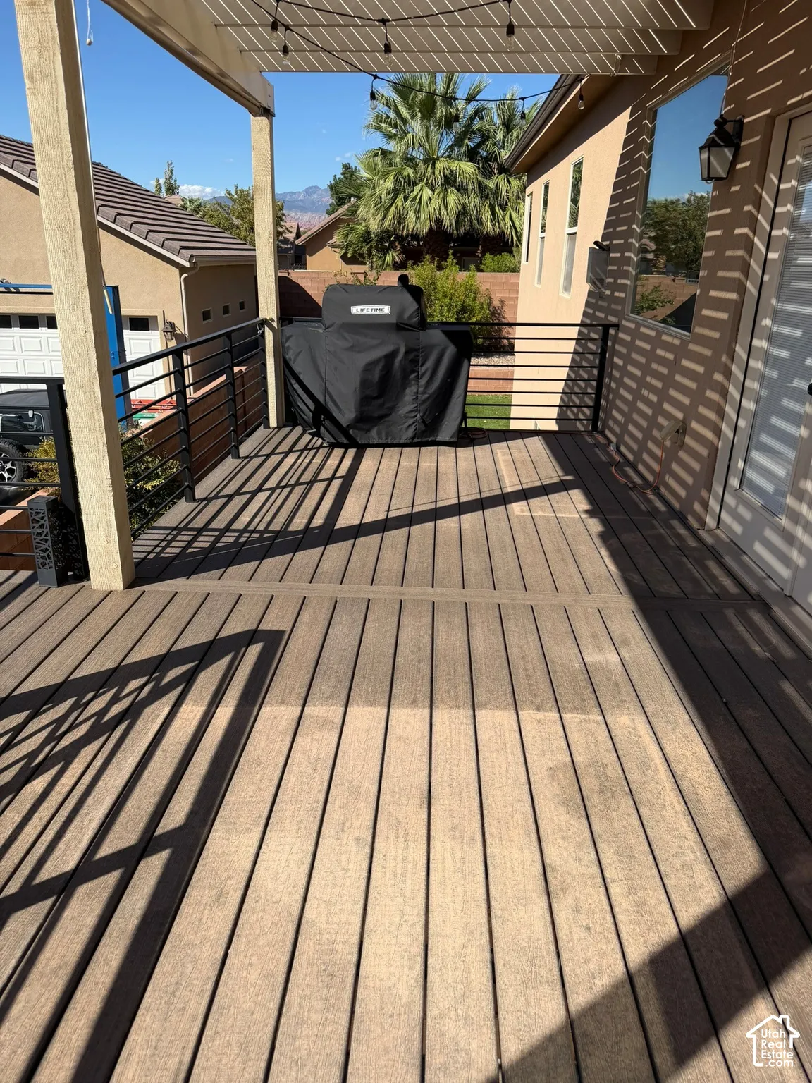 Expansive outdoor deck with composite decking, modern horizontal railing, and a shaded pergola