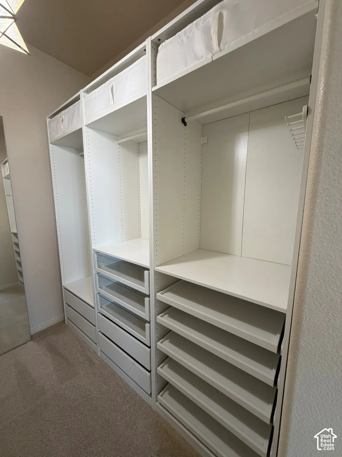 Built-in closet system featuring multiple shelves, drawers, and hanging rods for extensive organization