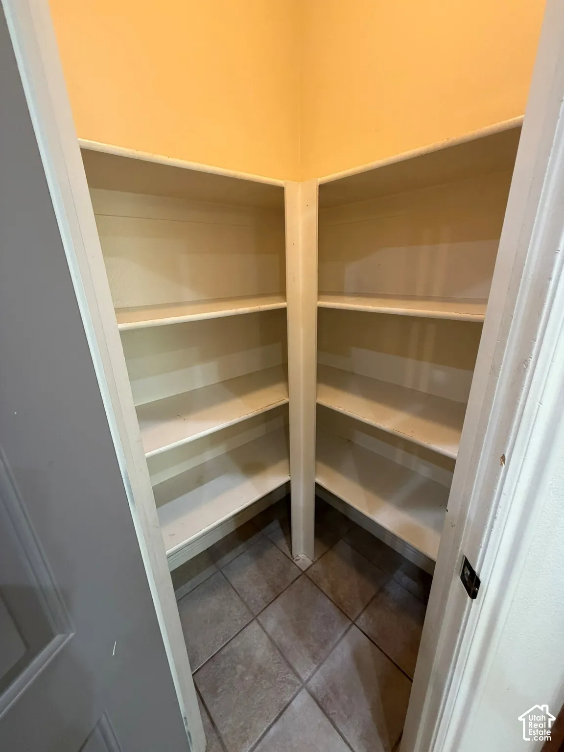 Built-in shelving with multiple levels, tile flooring, and neutral wall color