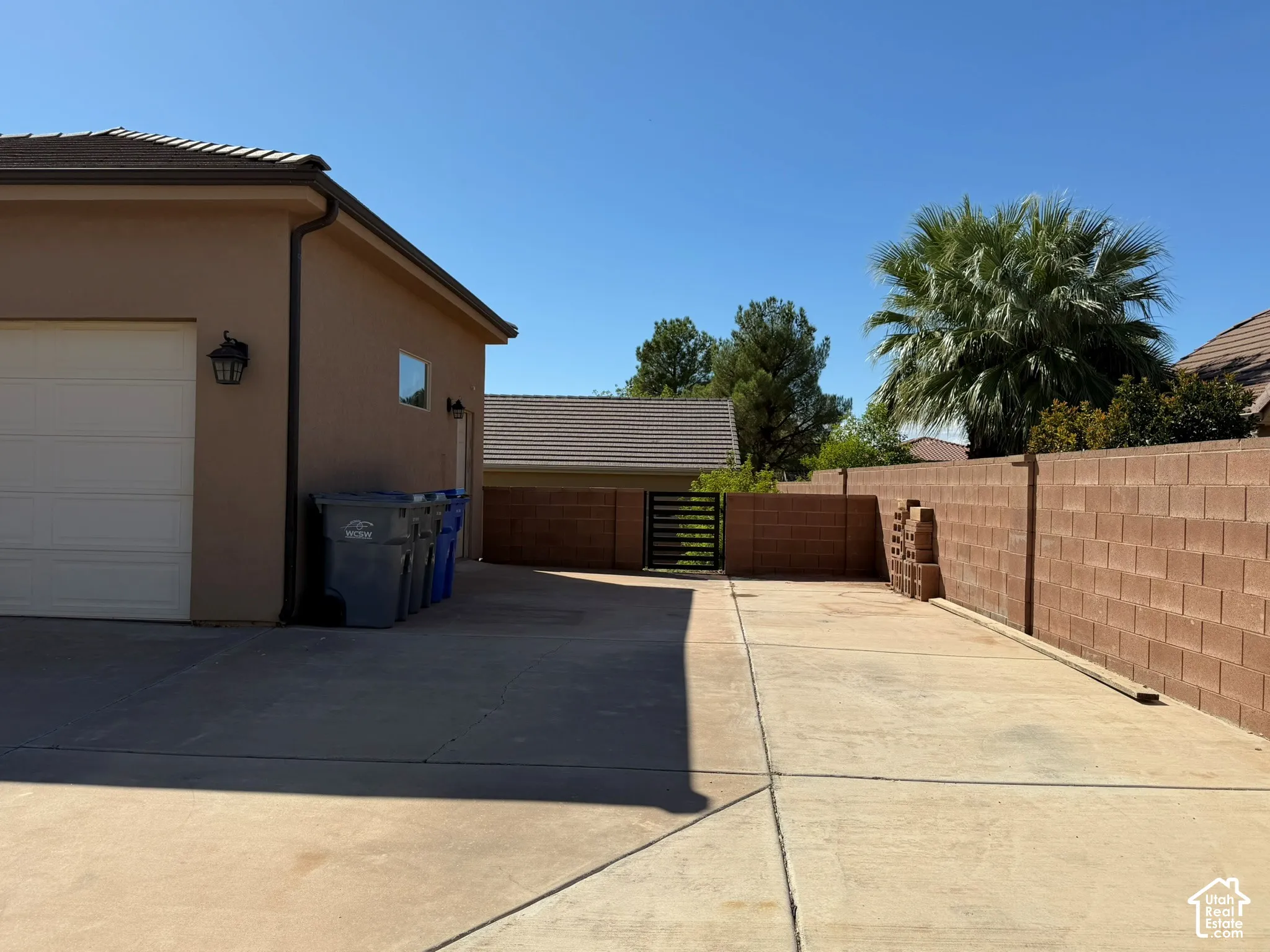 Exterior with stucco finish and a tiled roof, featuring a garage door with an exterior lantern light