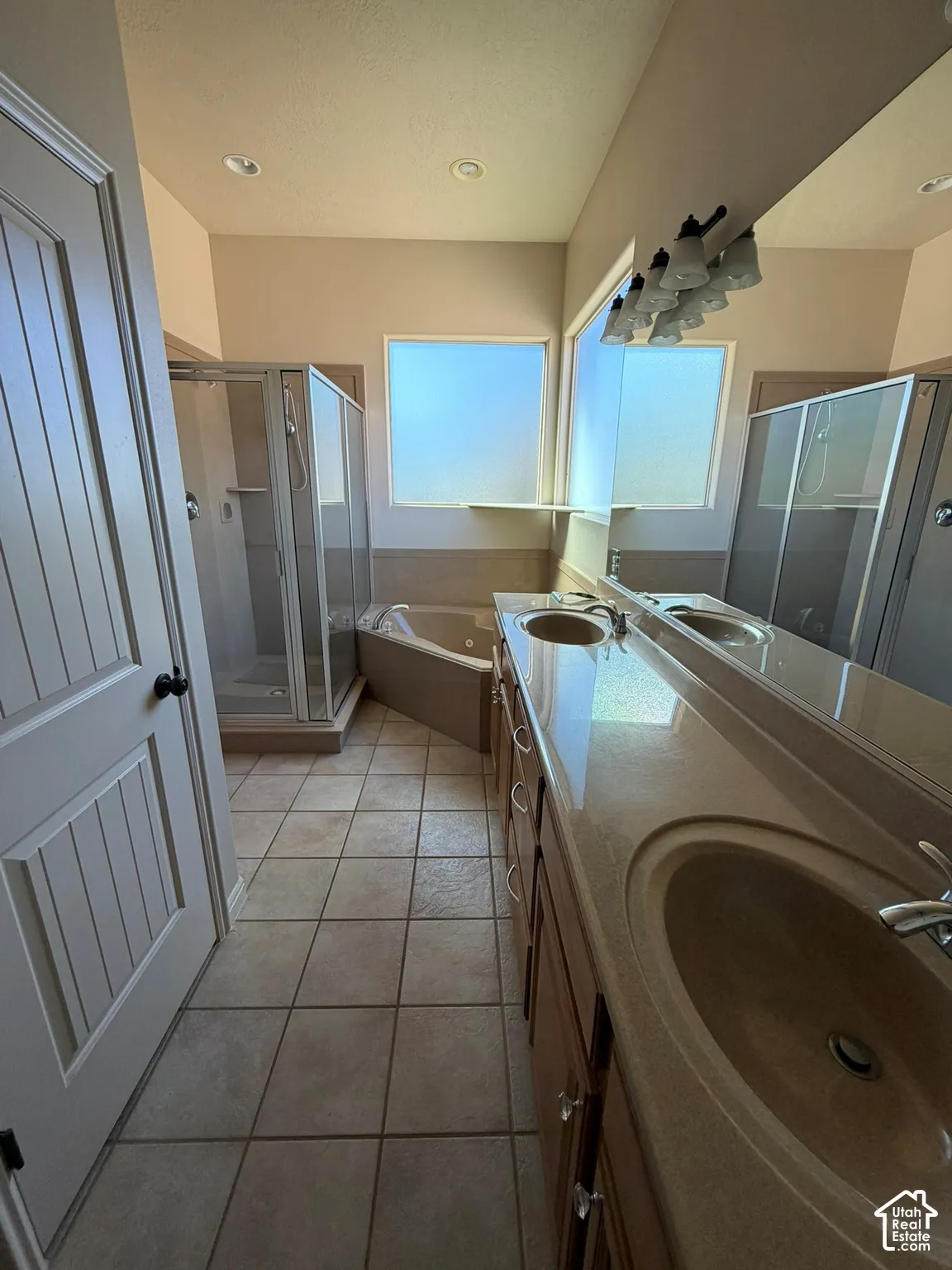 Dual vanity with integrated sinks, wood-finish cabinetry, and a large mirror