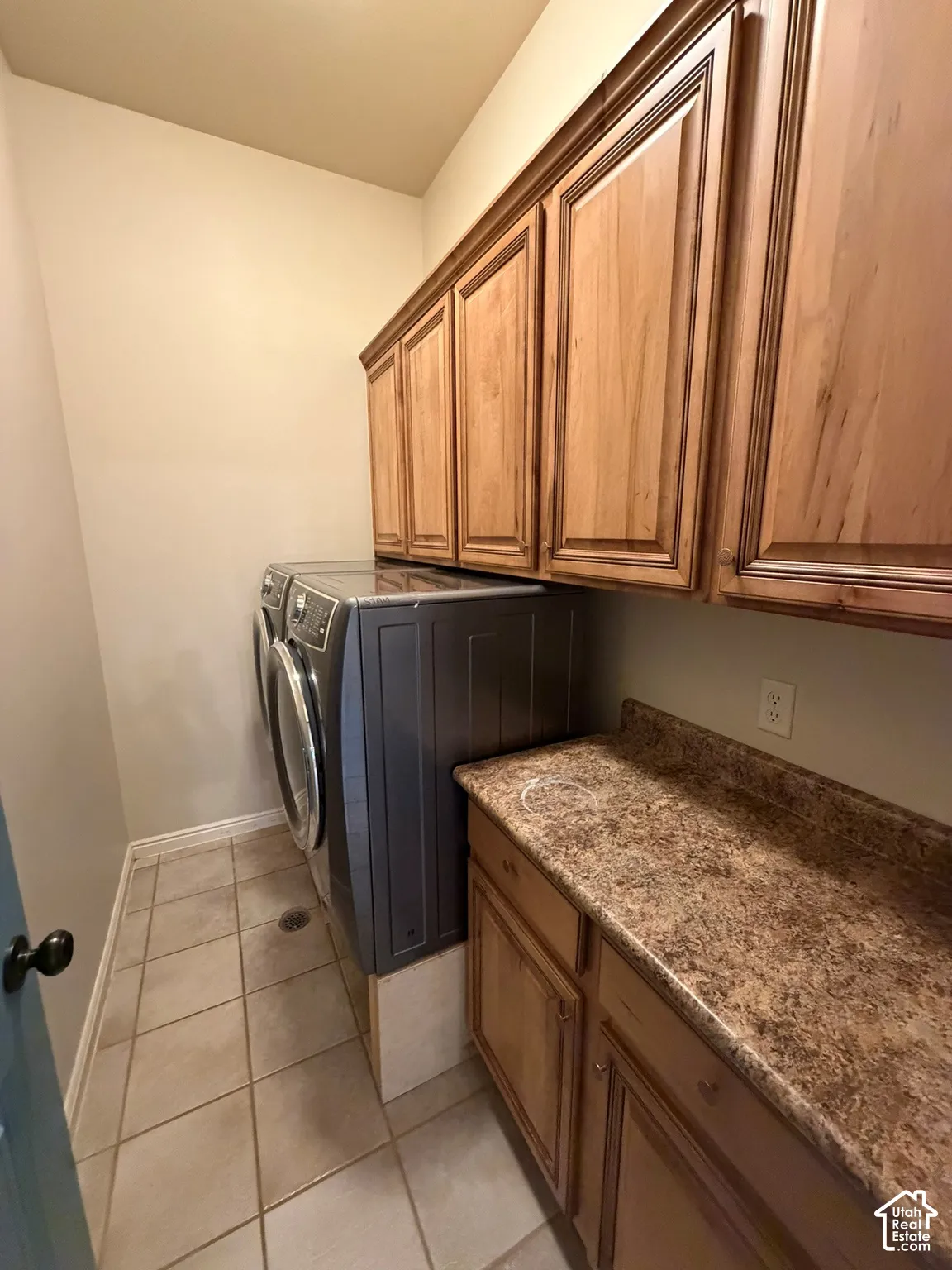 Tile flooring, wood-finish cabinetry, and a patterned countertop