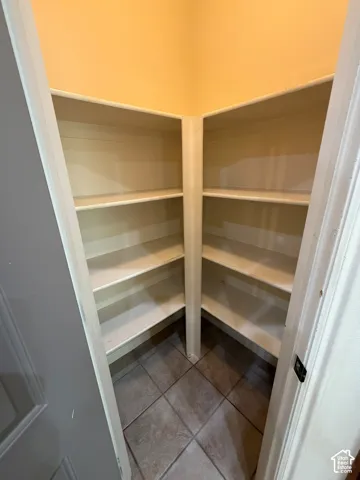 Built-in shelving with multiple levels, tile flooring, and neutral wall color