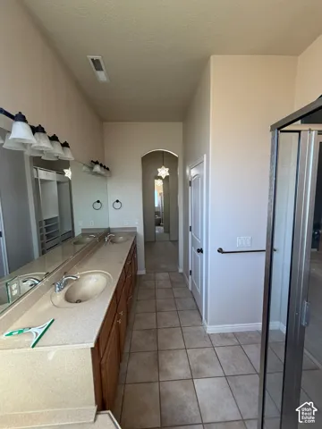 Dual vanity with integrated sinks, wood-finish cabinetry, and a large mirror