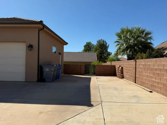 Exterior with stucco finish and a tiled roof, featuring a garage door with an exterior lantern light