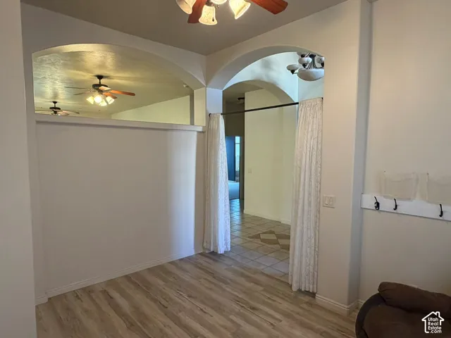 Archway entryways with decorative trim, wood-finish flooring, and a built-in coat rack
