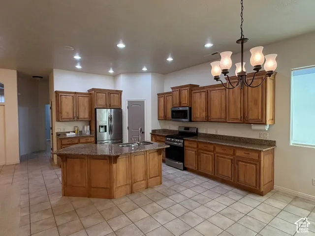 Kitchen featuring recessed lighting, a central island, wood cabinetry, stainless steel appliances, and tile flooring