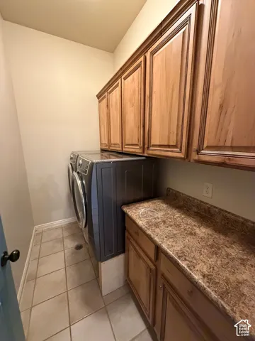 Tile flooring, wood-finish cabinetry, and a patterned countertop