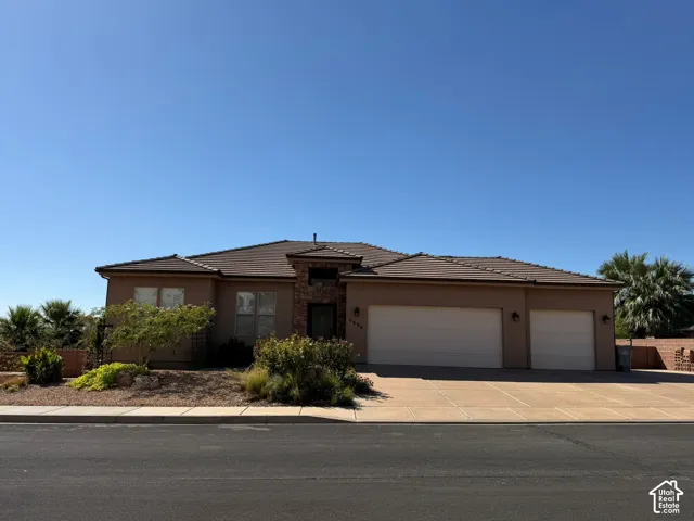 Stucco exterior with a tiled roof, multi-pane windows, and a two-car garage