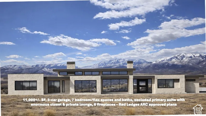 Modern architectural residence featuring extensive glazing, a stone exterior, a flat roofline, an integrated entry, and prominent mountain scenery