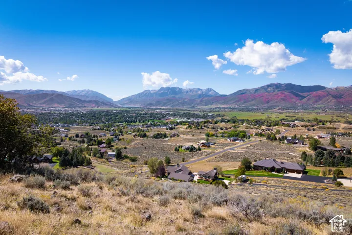 Expansive regional setting with a distant valley, mountainous terrain, and a clear blue sky