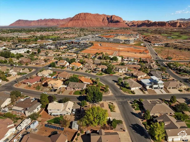 Expansive residential area with a prominent red rock mountain backdrop, featuring diverse architectural styles and established street infrastructure