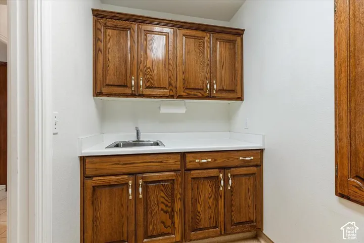 Built-in cabinetry with wood-finish doors, a countertop with an integrated sink, and a chrome faucet