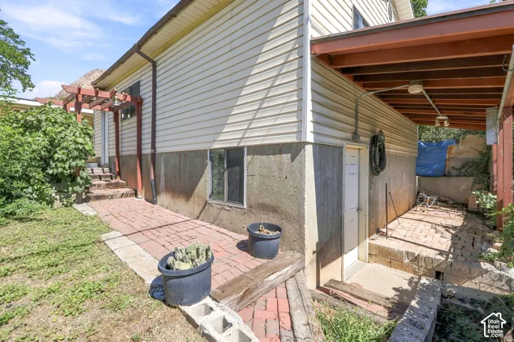 White horizontal siding with a concrete foundation, featuring a red brick-finish pathway