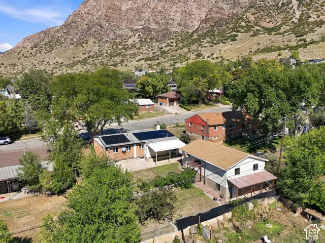Property featuring a brick exterior, solar panels, covered patio, and a mountain backdrop