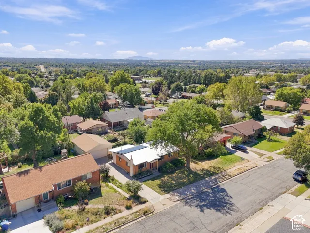Neighborhood setting with mature trees, paved streets, and residential rooftops