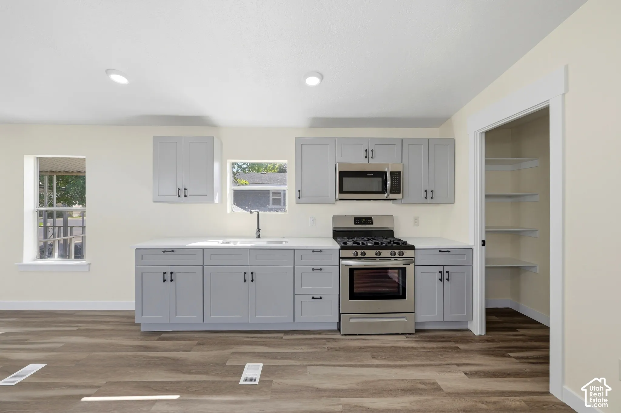 Kitchen featuring wood-finish flooring, recessed lighting, and light-toned cabinetry