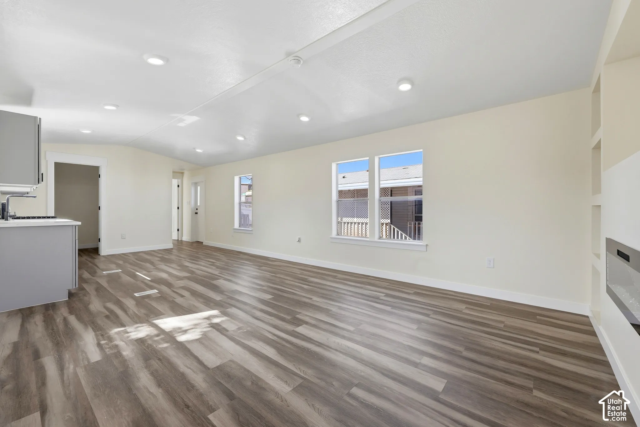 Spacious living area featuring wood-finish flooring, recessed lighting, and light-toned walls