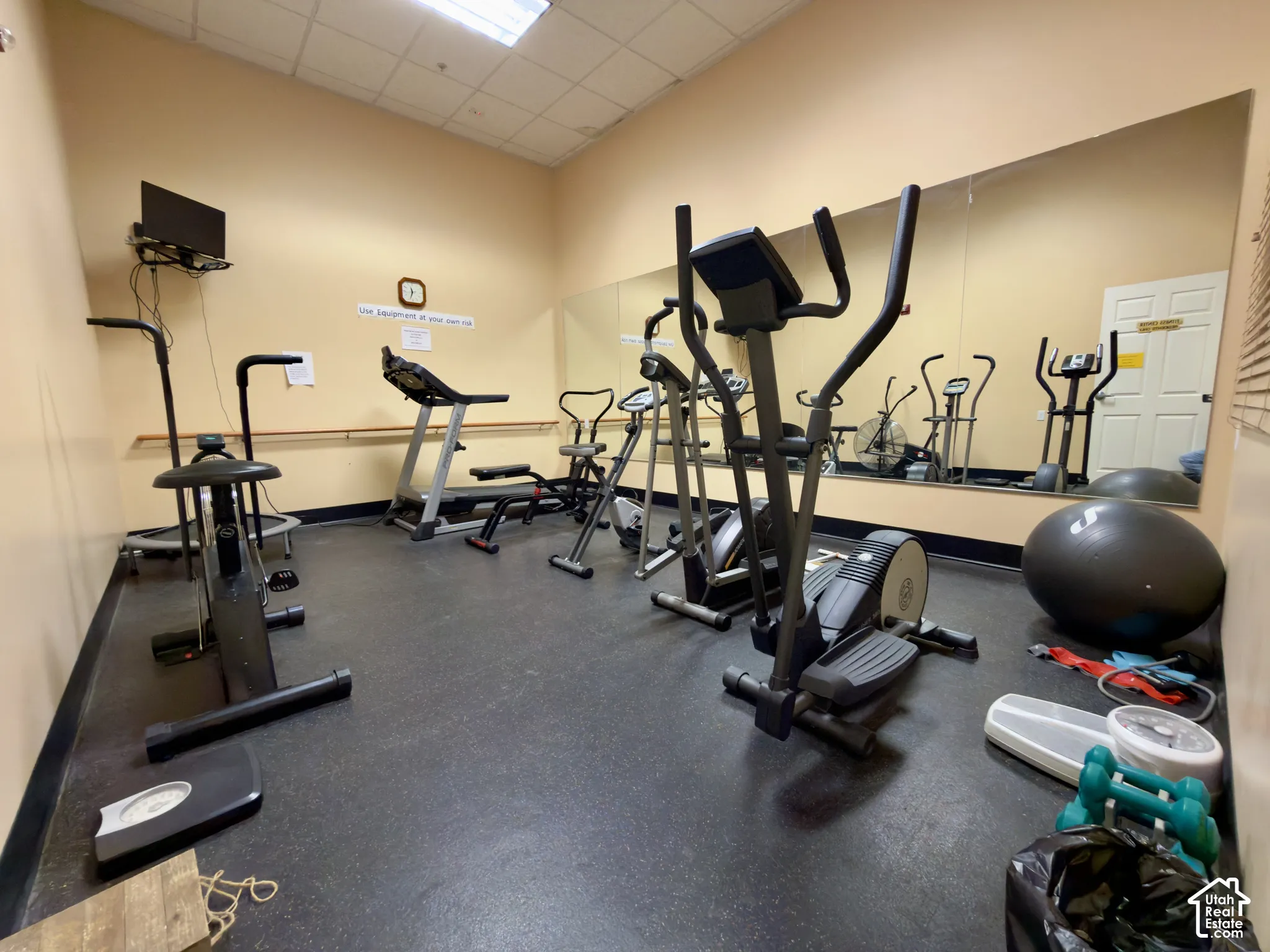 Fitness room with rubber flooring and full-height wall mirrors in the clubhouse
