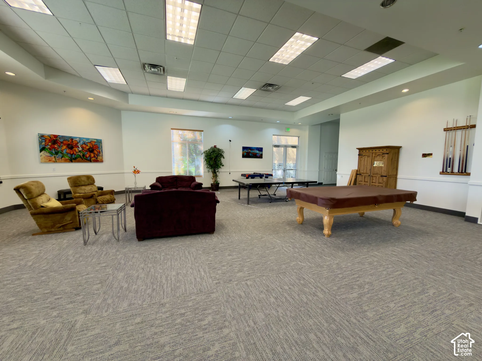 Spacious common area featuring game tables, couches & chairs